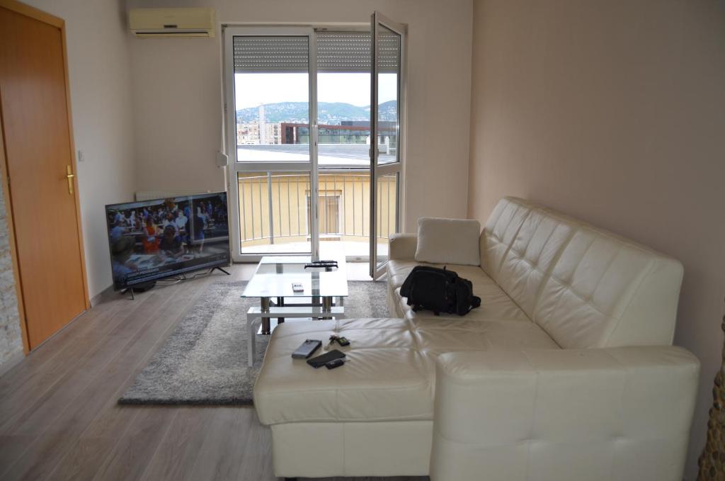 salon z białą kanapą i telewizorem w obiekcie Flat at the edge of the center + parking w Budapeszcie