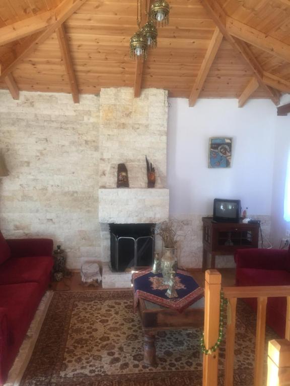 a living room with a fireplace and a red couch at Ionas House in Líppa