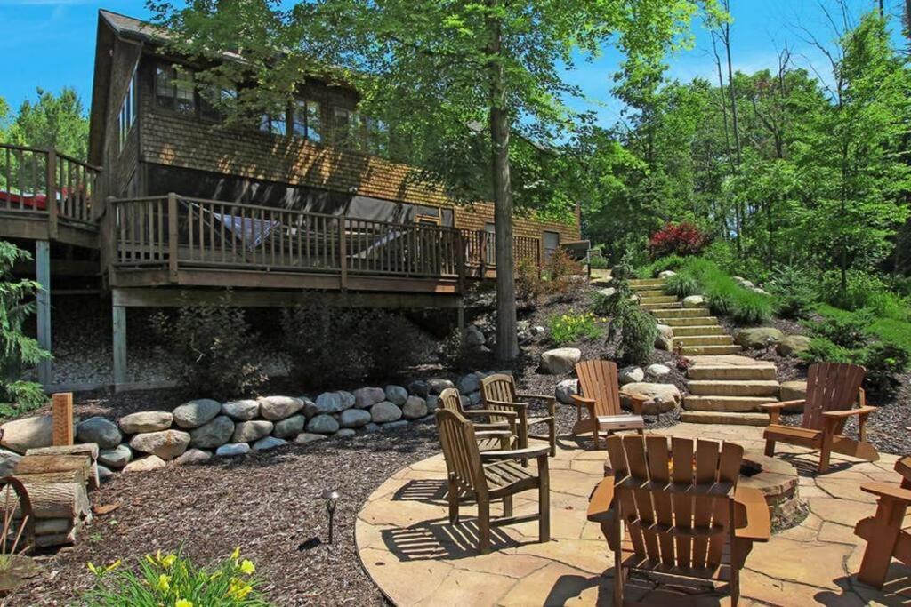 a patio with chairs and a deck and stairs at Secluded cabin on 10 acres - hot tub & game room! in Fennville