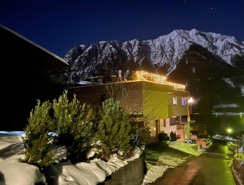 a building with a snow covered mountain in the background at Appartement Mountain Lake in Maurach