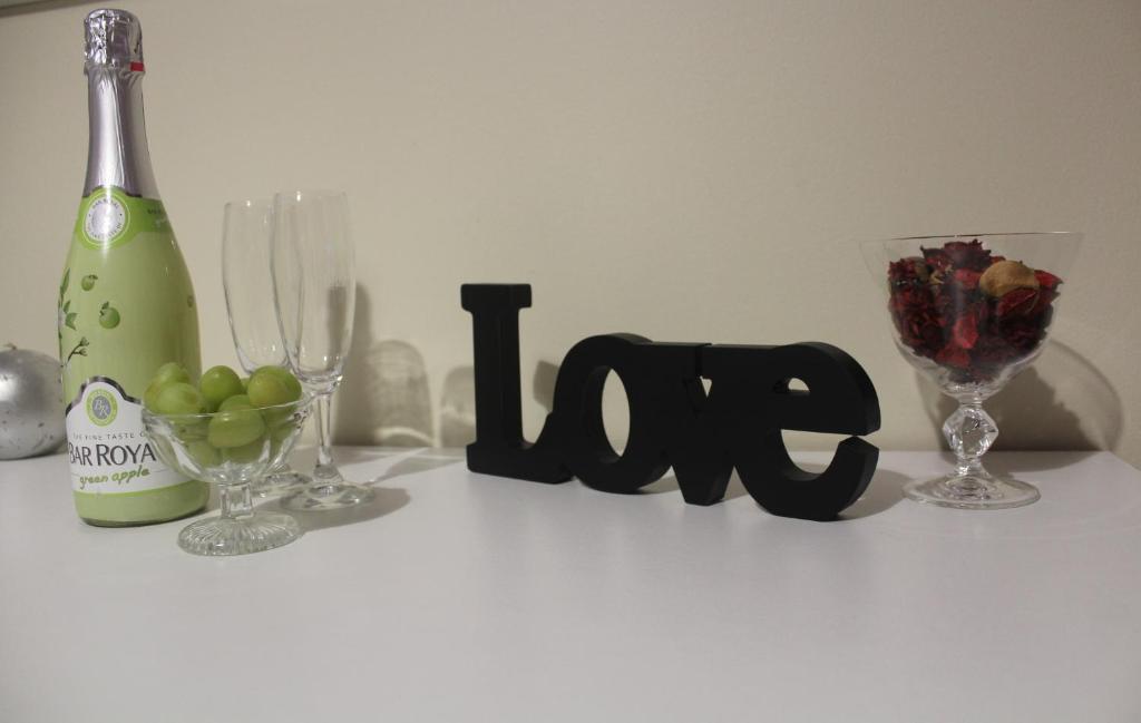 a white table with a bottle of wine and wine glasses at Apartamento Lara in Albufeira