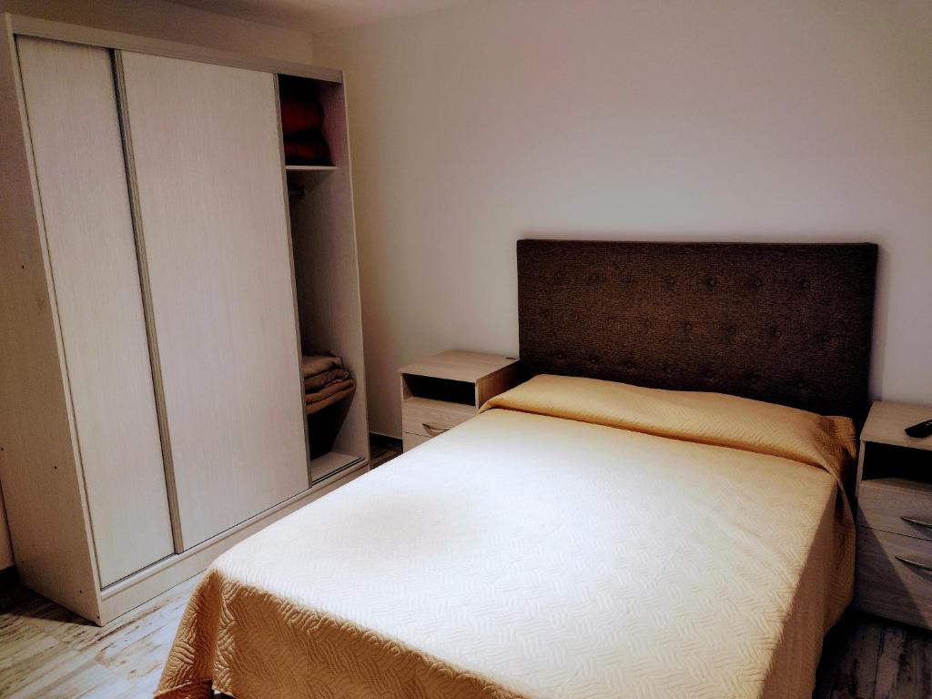 a small bedroom with a bed and a closet at Condominio Plaza Italia - Cochera gratis in Mar del Plata