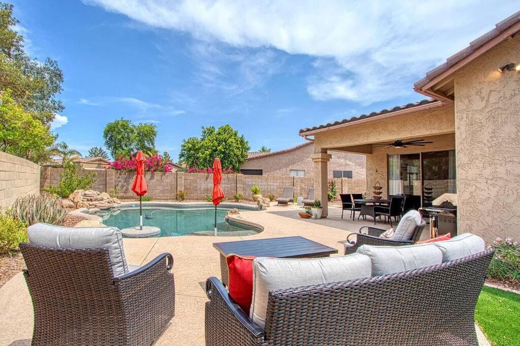een achtertuin met een zwembad met stoelen en een tafel bij OLIVE - Resort-Style Yard with Pool & Near Golf in Chandler