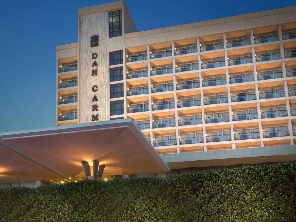 a building with a hedge in front of it at Dan Carmel Haifa in Haifa