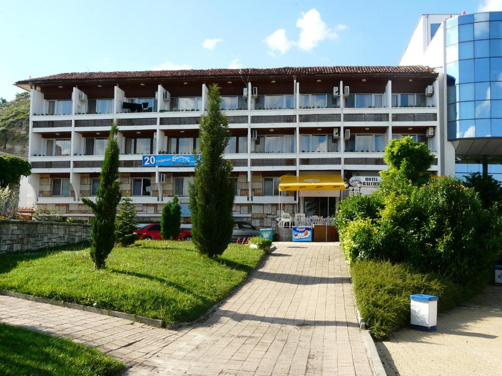 ein großes Gebäude mit Bäumen davor in der Unterkunft Family Hotel Balchik in Baltschik