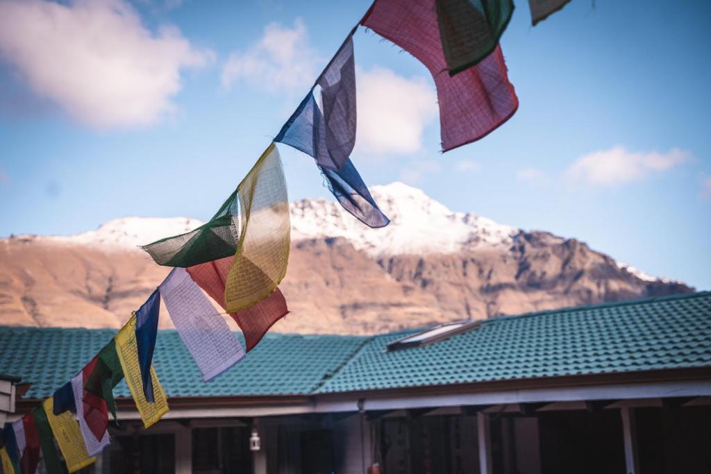 a group of flags hanging from a building with a mountain at Ora Retreat in Queenstown