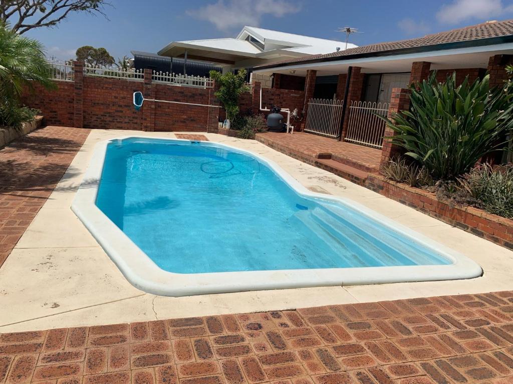 a large swimming pool in front of a house at Beach front 4 x2 Home with pool in Geraldton