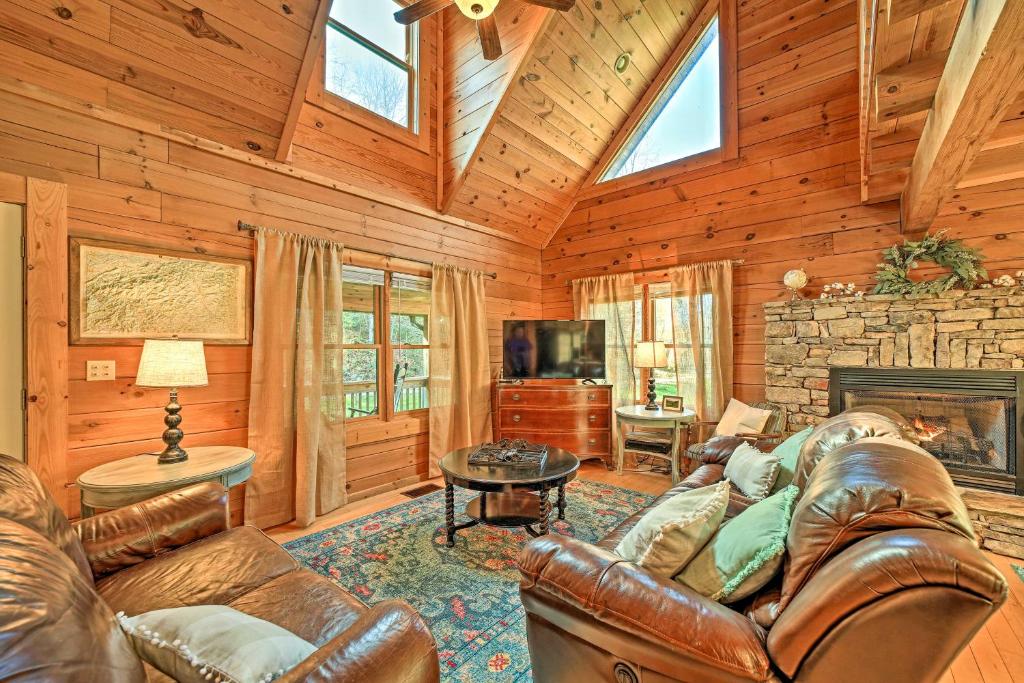 a living room with leather furniture and a fireplace at Creekside Bryson City Cabin with Private Hot Tub in Bryson City