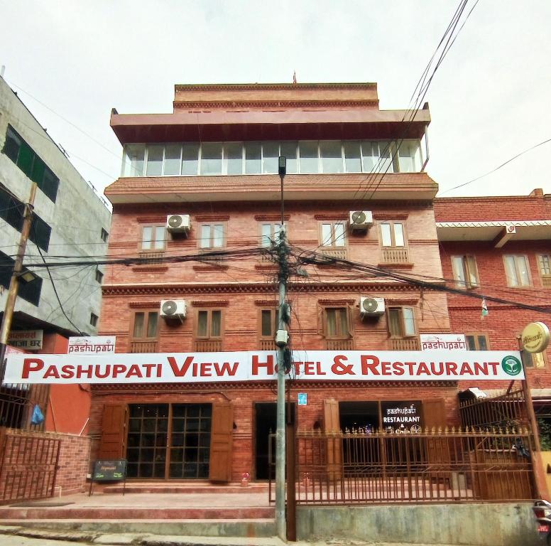 un bâtiment avec un panneau devant lui dans l'établissement Pashupati View Hotel, à Katmandou