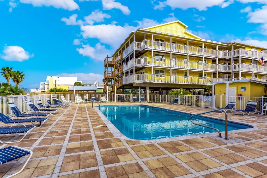 una piscina frente a un hotel con sillas y un edificio en Lagoon Run, en Gulf Shores