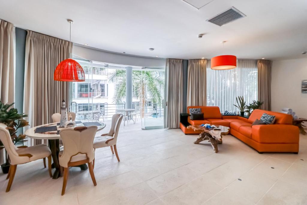a living room with an orange couch and a table at Hermosa Waves A2 in Playa Hermosa
