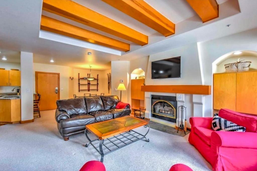 a living room with a leather couch and a fireplace at Red Snowshoes & Stay in Solitude in Solitude
