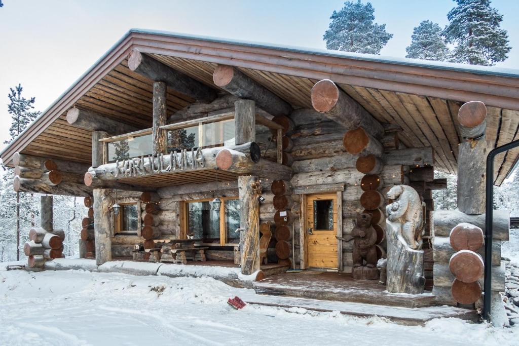 uma cabana de madeira na neve em Spectacular Rural Log House with 2 Saunas next to a beautiful lake em Kuusamo