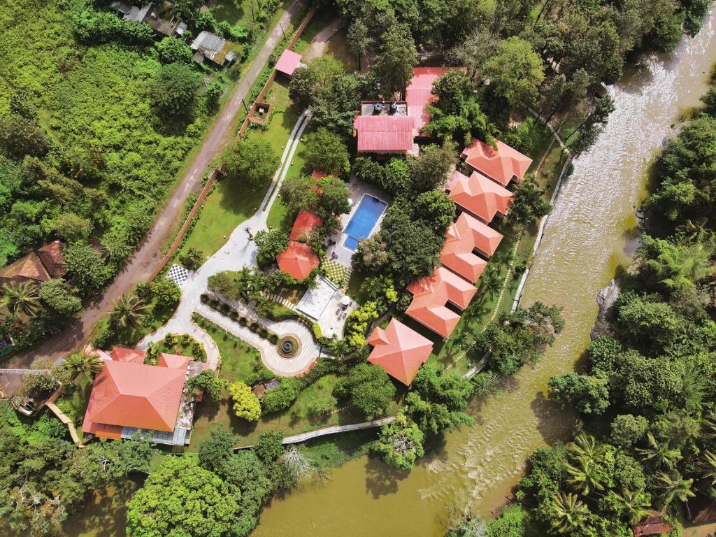 an aerial view of a house with a river at Regenta Jungle Resort Kabini Springs in Begūr