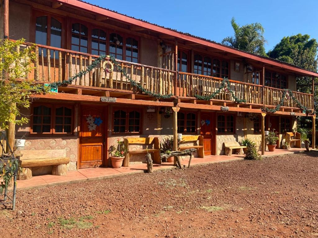 ein großes Gebäude mit einem Balkon sowie Tischen und Bänken in der Unterkunft Cabañas Quinta San Agustin in Zacatlán