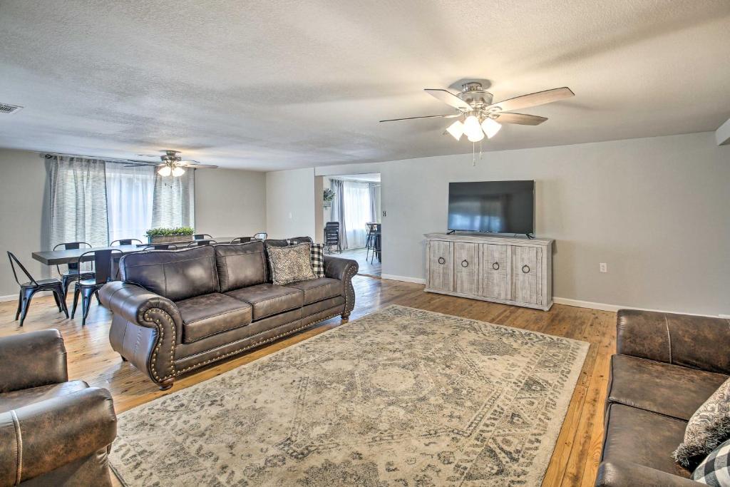 a living room with a couch and a flat screen tv at 11 Mi to Lake Ouachita Family Cabin with Yard in Royal