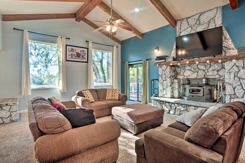 ein Wohnzimmer mit Sofas und einem Steinkamin in der Unterkunft Yosemite Home with Deck Less Than 4 Mi to Bass Lake! in Oakhurst