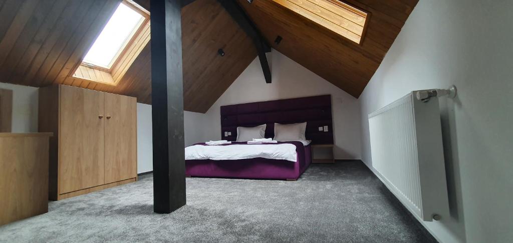 ヴァトラ・ドルネイにあるCasa Sebiのベッドルーム1室(紫のシーツが敷かれたベッド1台付)