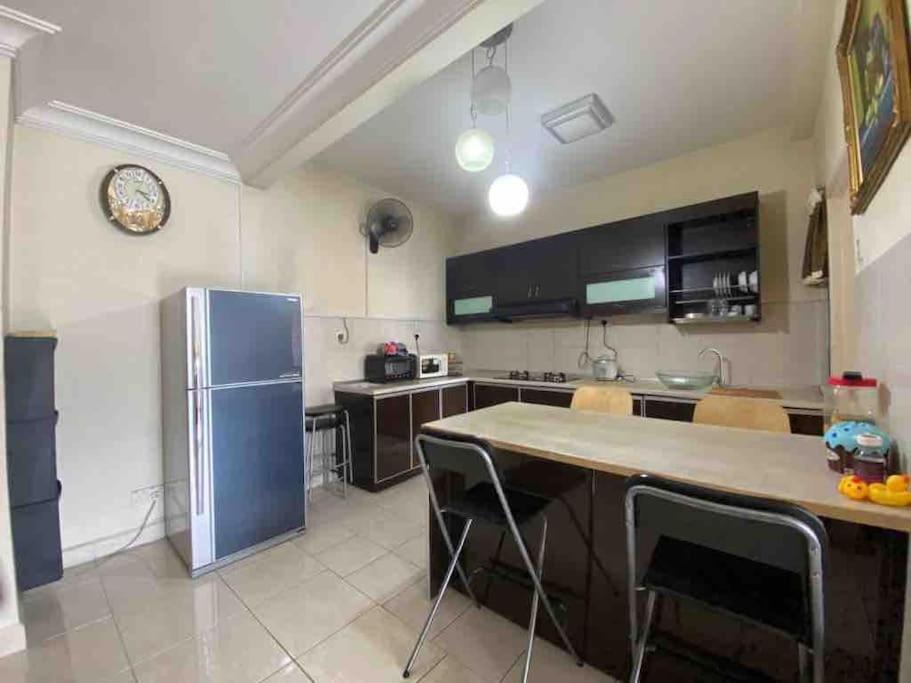 a kitchen with a refrigerator and a table and chairs at CASA TROPICANA - 2-Room CONDO with facilities in Petaling Jaya