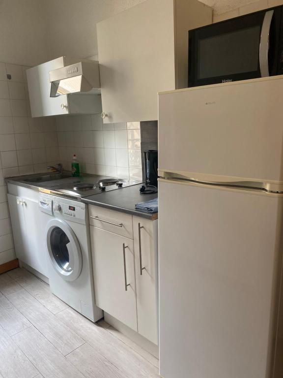 eine Küche mit einem Kühlschrank und einer Waschmaschine in der Unterkunft Arcole 2-Studio Beziers Centre -Wifi - Tv connectée in Béziers