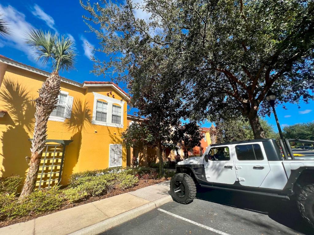 un camion bianco parcheggiato di fronte a una casa gialla di Grand Superior 3BR Townhouse near Disney Parks a Kissimmee