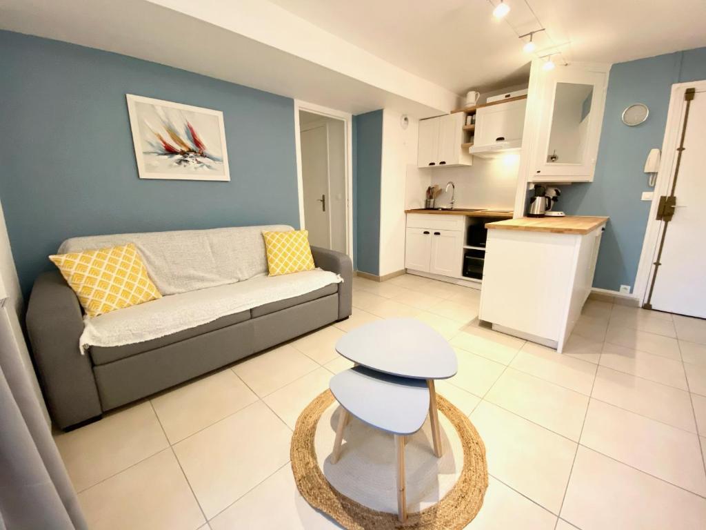 ein Wohnzimmer mit einem Sofa und einer Küche in der Unterkunft Albiréo YourHostHeper in Luc-sur-Mer