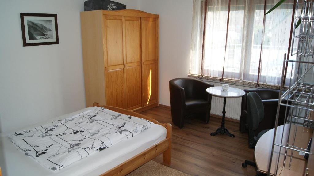 a bedroom with a bed and two chairs and a table at Komplette Wohnung im schönen Weserbergland / Heyen in Heyen