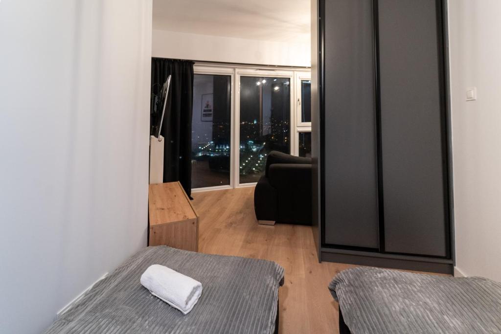 1 dormitorio con 2 camas y sala de estar con ventana en Panorama Capital Tito - 16 piętro en Rzeszów