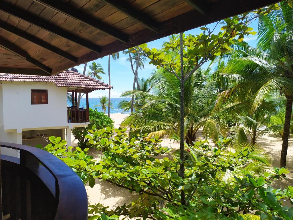 a view of the beach from the porch of a house at Tropical Garden in Tangalle