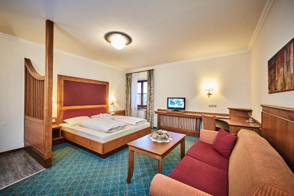 a hotel room with a bed and a couch at Hotel zur Post in Bad Koetzting