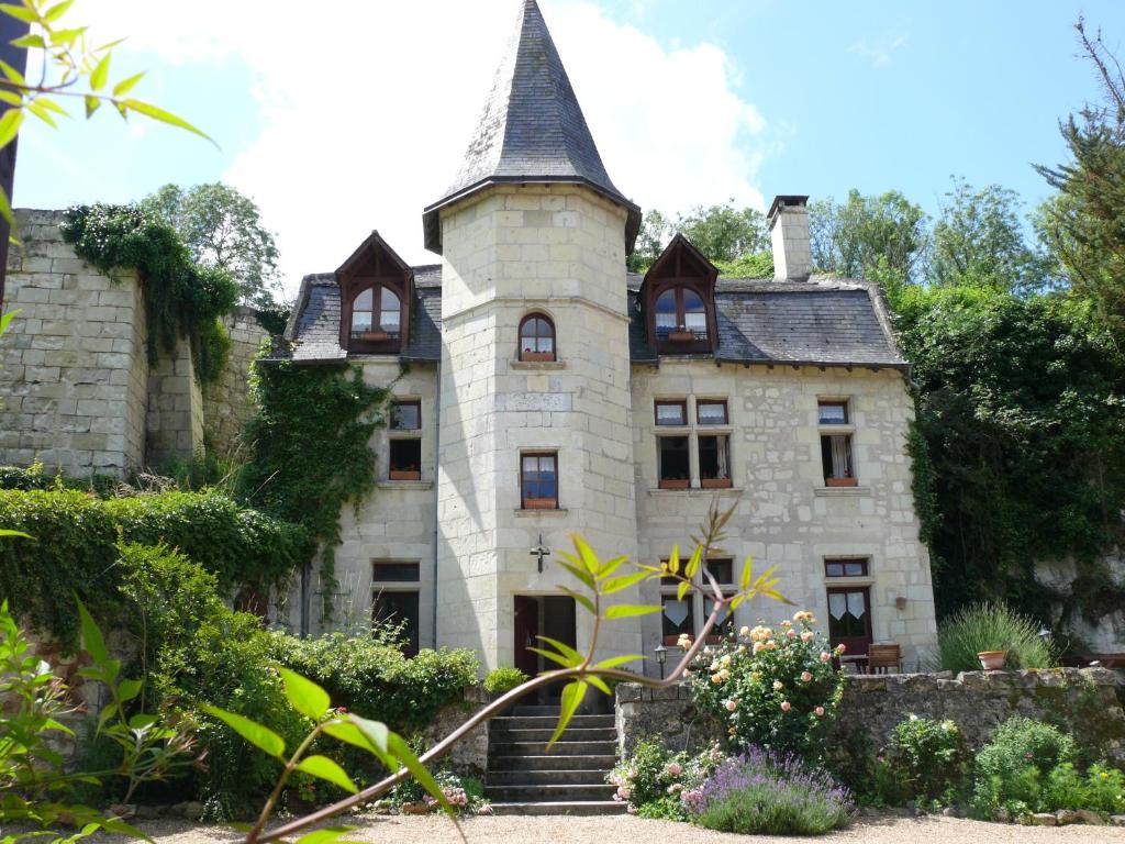 uma antiga casa de pedra com uma torre e escadas em Le Petit Hureau em Saumur