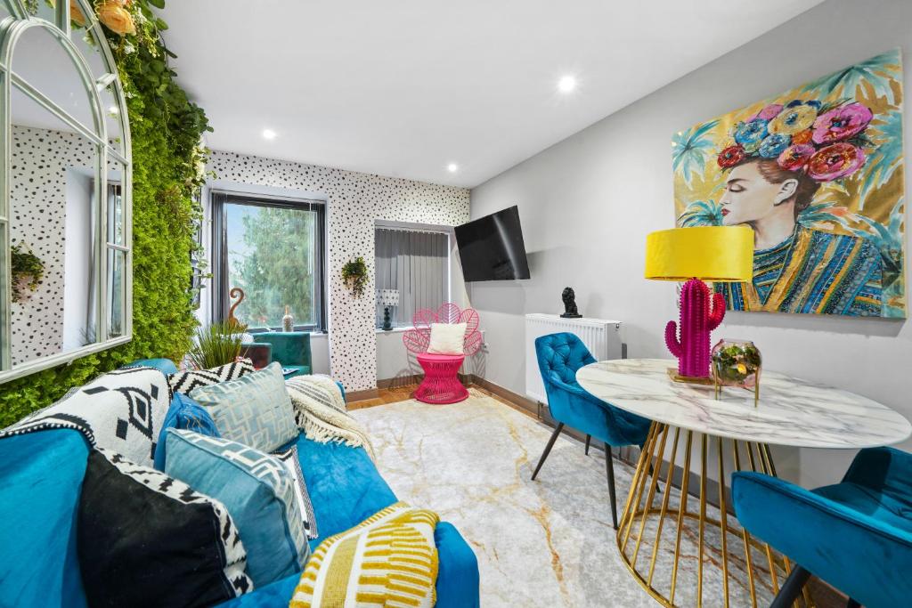 a living room with a blue couch and a table at Lushh Maidstone Apartments in Kent