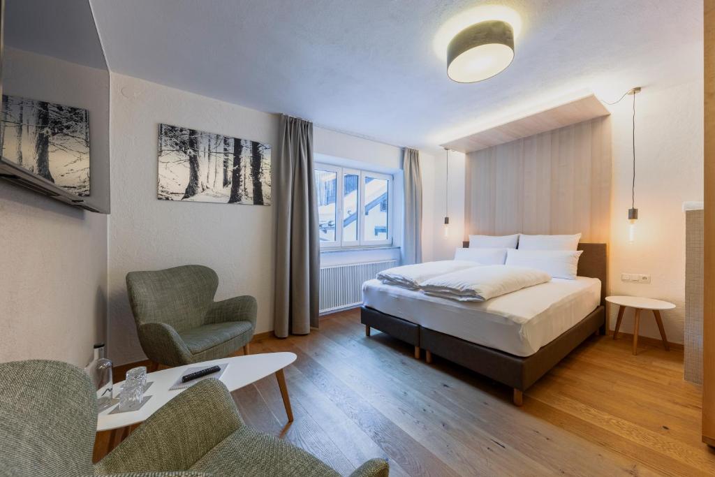 a bedroom with a bed and a desk and a chair at MALI by m3 in Sankt Anton am Arlberg