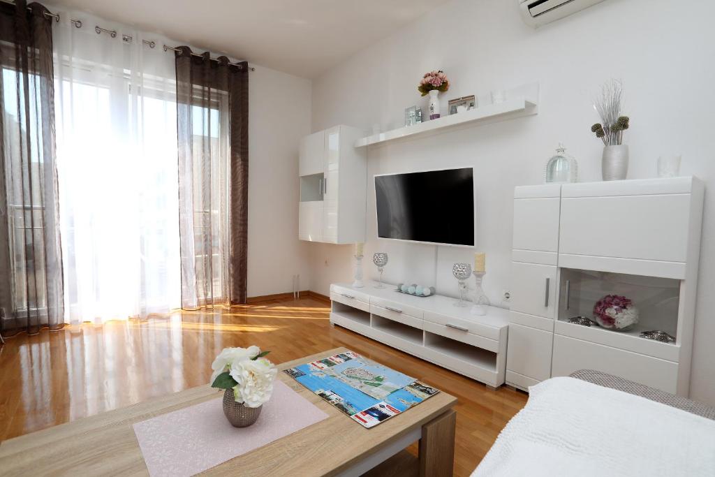 Televízia a/alebo spoločenská miestnosť v ubytovaní Apartmani Kolak