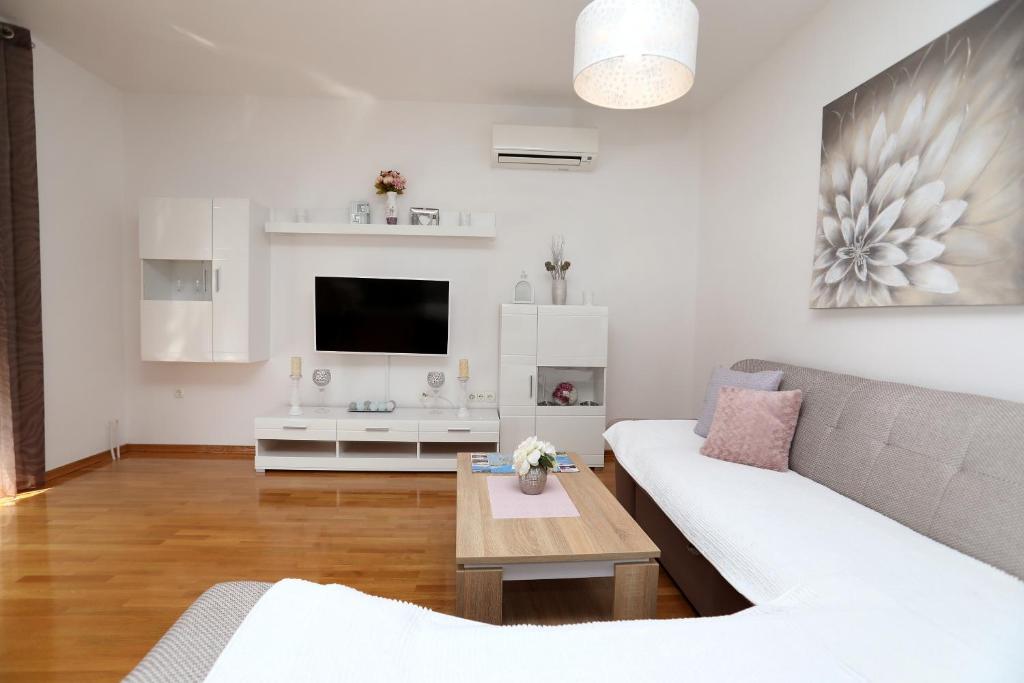Televízia a/alebo spoločenská miestnosť v ubytovaní Apartmani Kolak