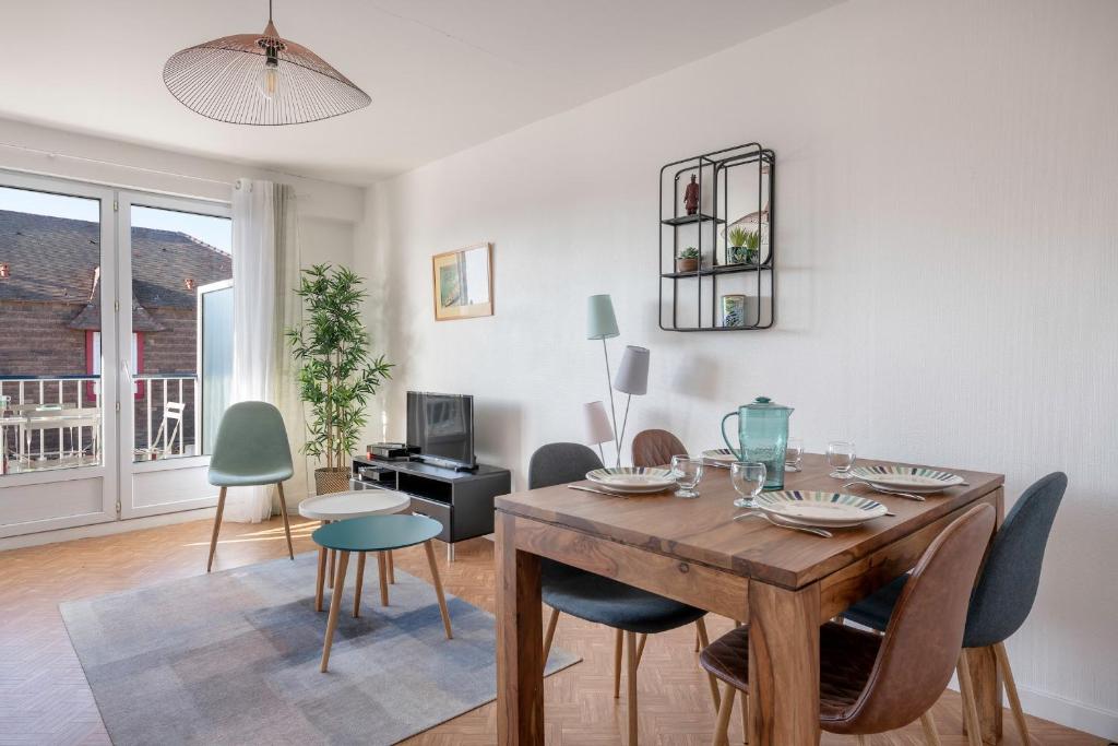 un salon avec une table et des chaises en bois dans l'établissement Bel appartement - 400m plage de la Baule, à La Baule