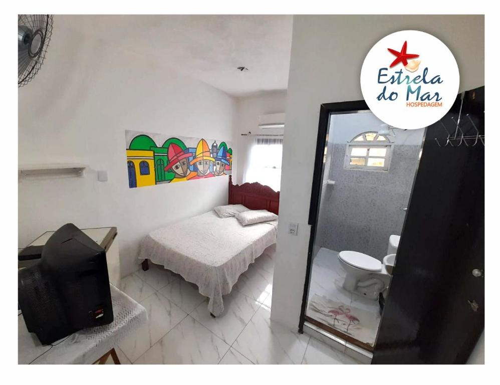 a room with a bed and a mirror and a television at Toca do Pato Hospedagem in Trindade
