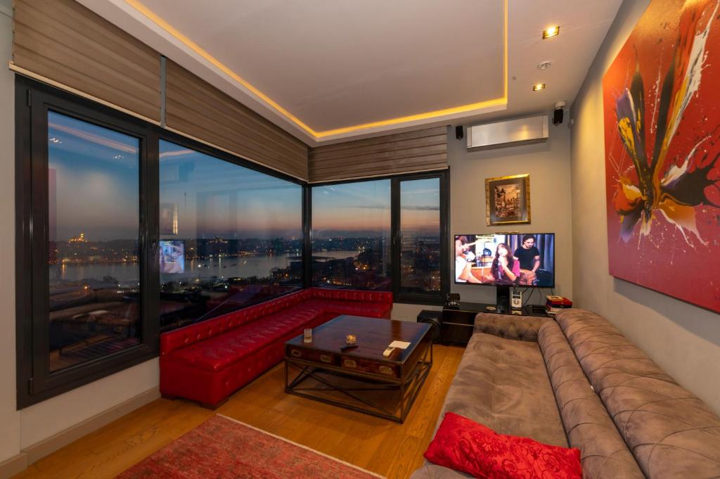a living room with a red couch and a large window at O'Pera Okanlı Suites in Istanbul
