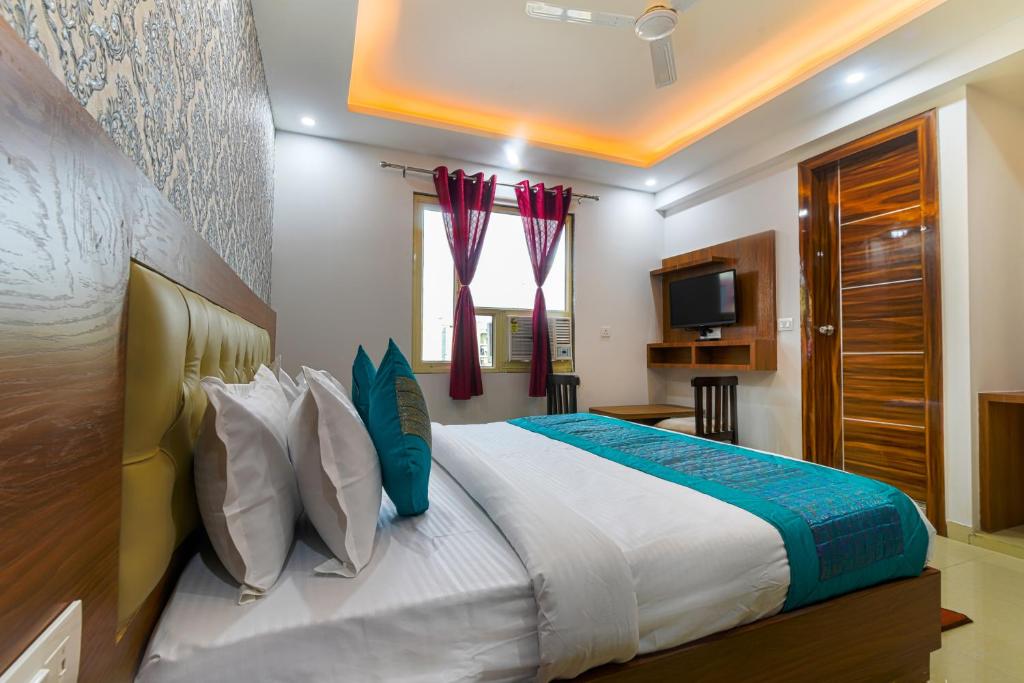 a bedroom with a large bed and a television at Hotel Urban Tree in New Delhi