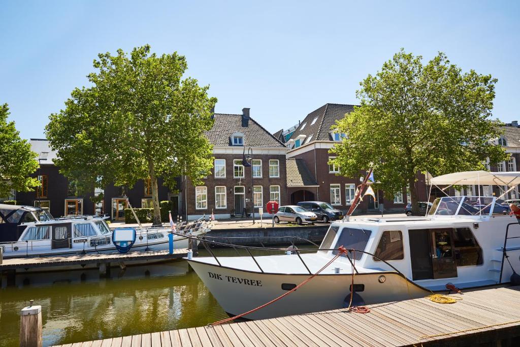 een boot is aangemeerd op een dok in een haven bij The Yard hotel Zuidkade in Veghel