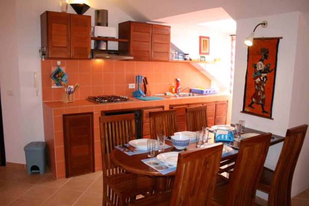 a kitchen with a wooden table with chairs and a dining room at Casa Bahia 10 Grande Penthouse in Santa Maria