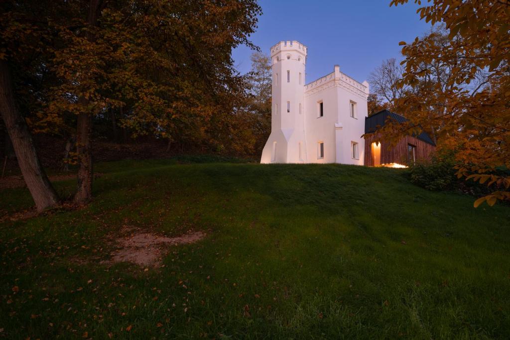 a castle on top of a grassy hill at night at Szobi Malomkert Bagolyvár in Szob