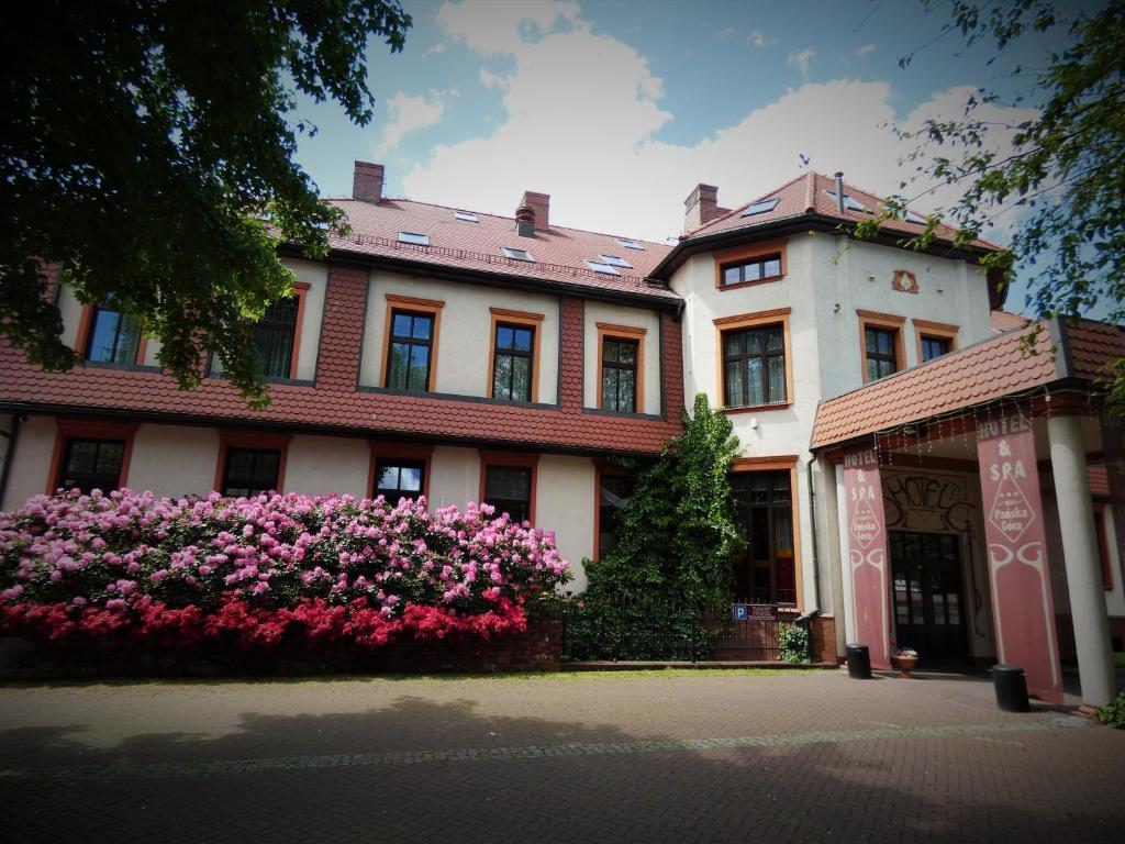 ein Gebäude mit rosa Blumen davor in der Unterkunft Pańska Góra in Jaworzno