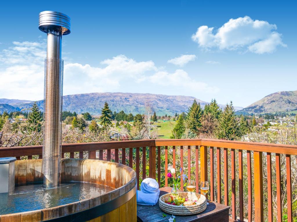 bañera de hidromasaje en una terraza con vistas a las montañas en Archway Motels & Chalets, en Wanaka