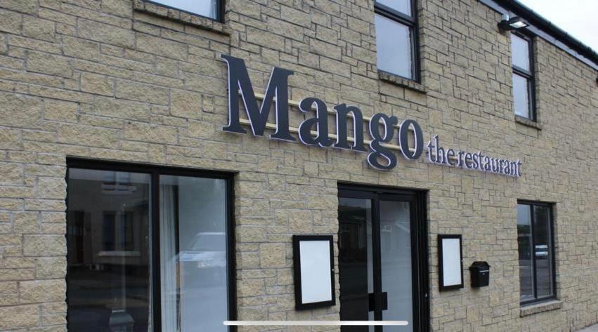 HaggsにあるMango the Hotelの煉瓦造りの建物側の看板