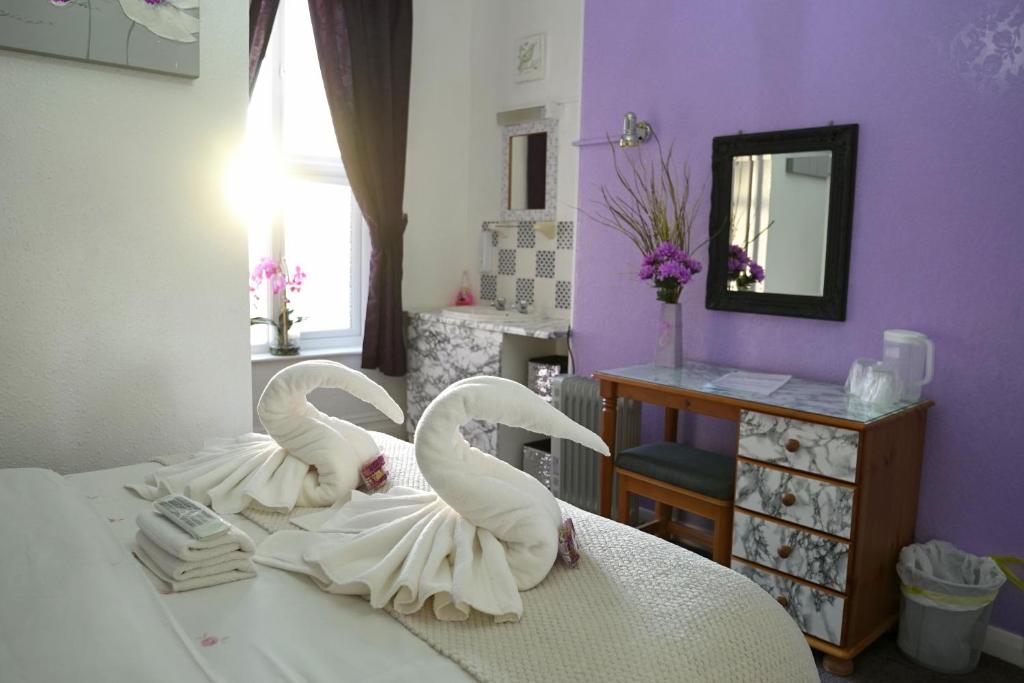 two white swans are sitting on a bed at The Eastleigh in Skegness