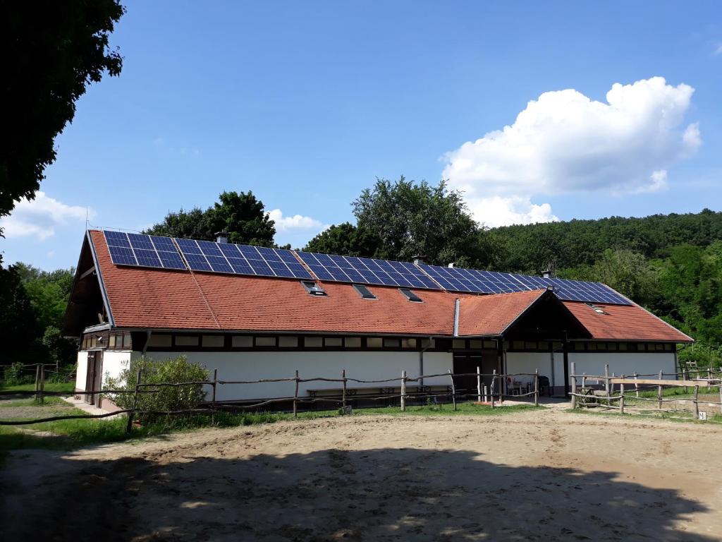 un granero con paneles solares en el techo en Szobi Malomkert Lovarda, en Szob