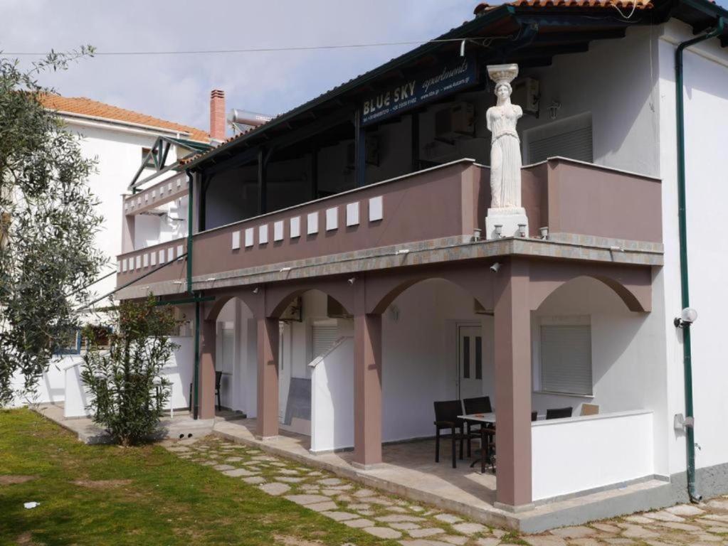 a building with a balcony with a table on it at Blue Sky Villas in Skala Potamias
