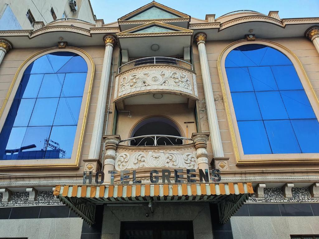 チェンナイにあるHOTEL GREENS - Puratchi Thalaivar Dr M G Ramachandran Central Railway Station Chennaiの窓3つとバルコニー付きの建物