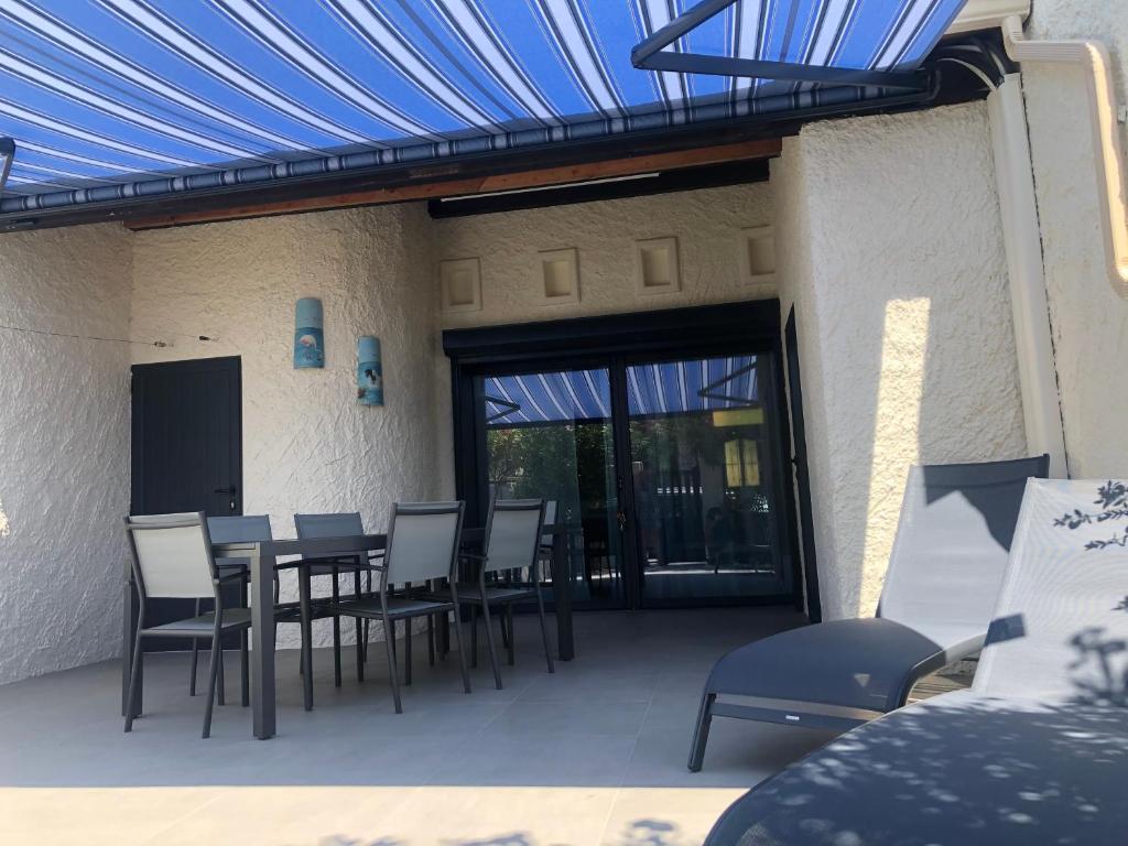 Villa ZEN في لو غراو دو روا: فناء مع طاولة وكراسي وسقف أزرق